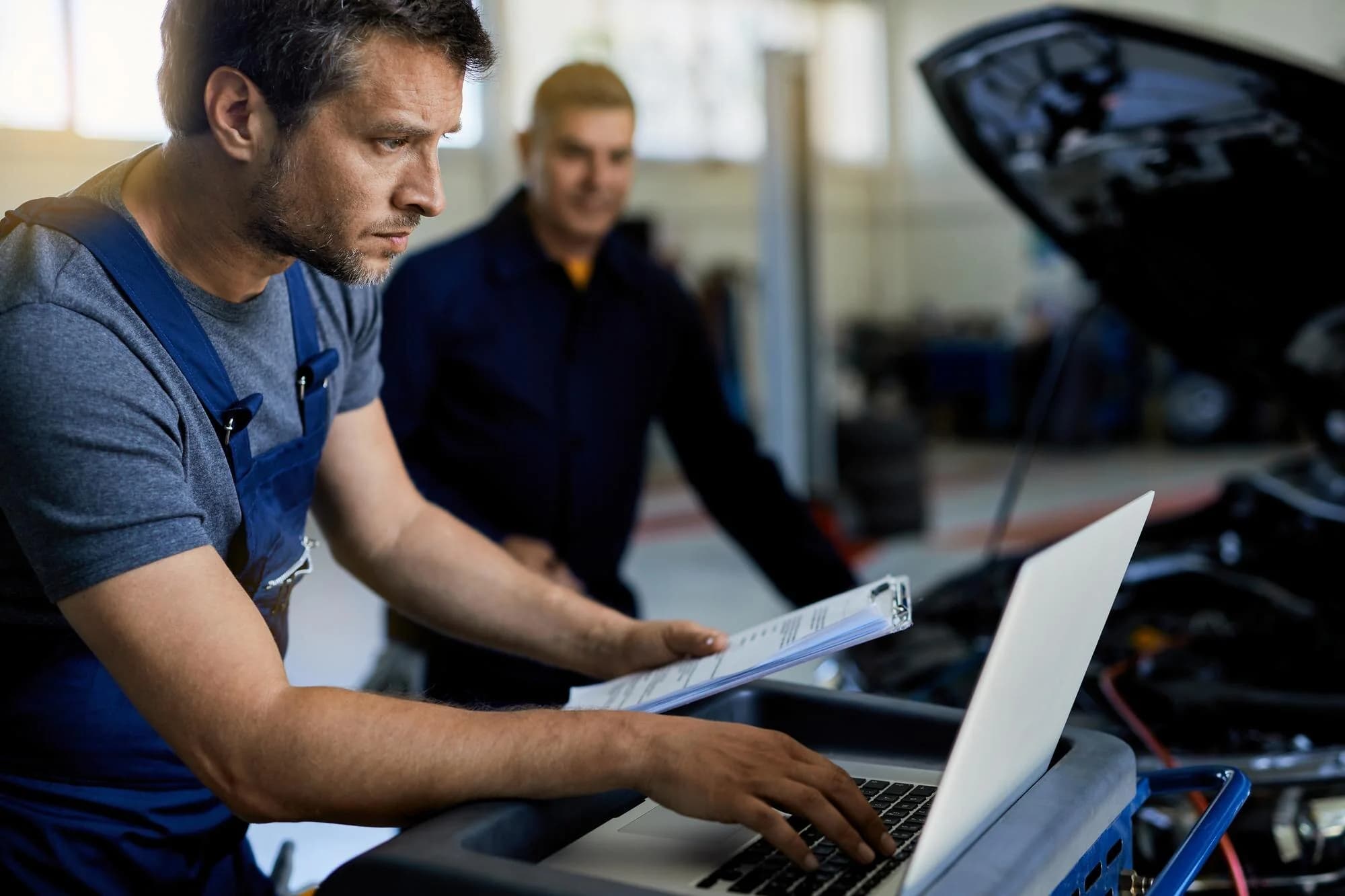 Zwei Fachkräfte bei der digitalen Fahrzeugdiagnose